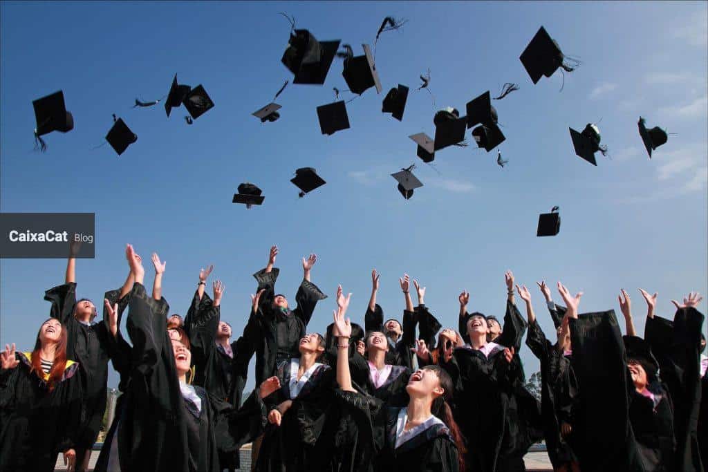 Newly Graduated People Wearing Black Academy Gowns Throwing Hats Up in the Air