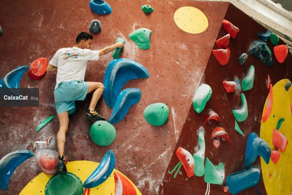 a man climbing up the side of a climbing wall