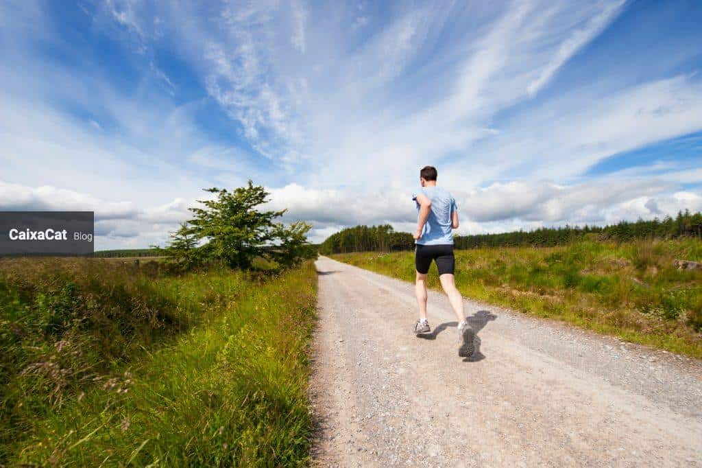 man running on road near grass field